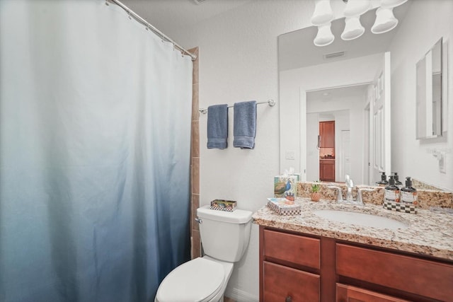 bathroom featuring a shower with curtain, vanity, and toilet