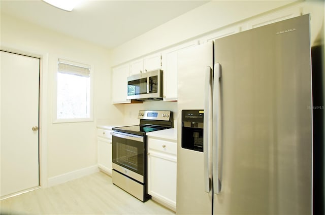 kitchen featuring stainless steel appliances, light hardwood / wood-style flooring, and white cabinets