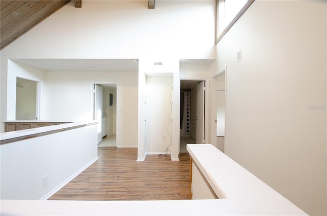 hall featuring high vaulted ceiling and light hardwood / wood-style flooring