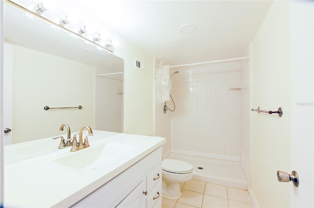 bathroom with vanity, tiled shower, tile patterned floors, and toilet