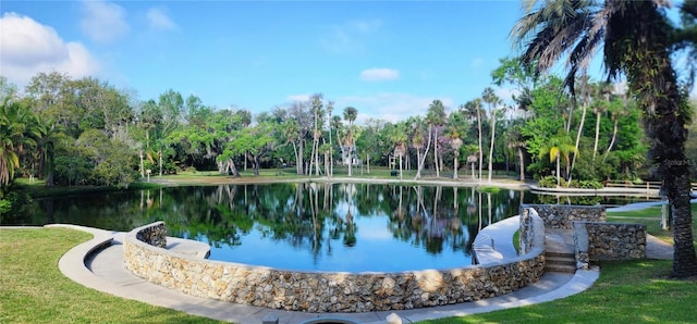 view of home's community featuring a water view and a lawn