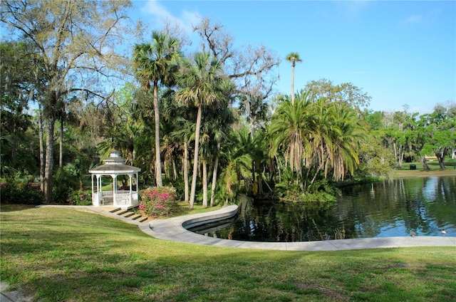 surrounding community with a gazebo, a water view, and a yard