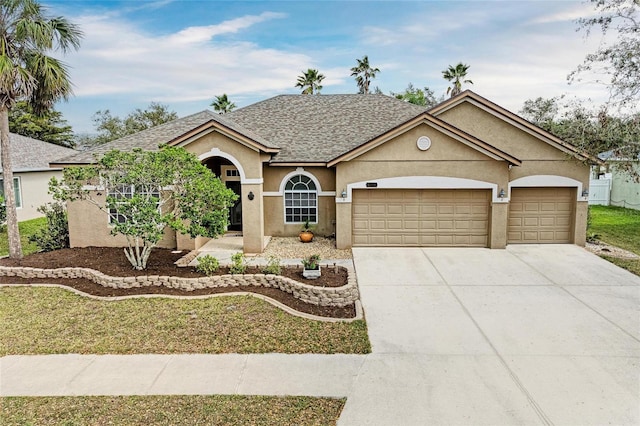 view of front facade featuring roof with shingles, driveway, an attached garage, and stucco siding