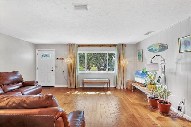 living room with a textured ceiling and light wood-type flooring