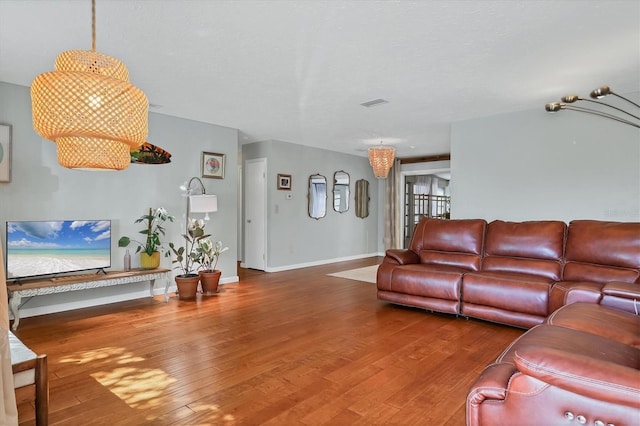 living room with wood-type flooring and a textured ceiling