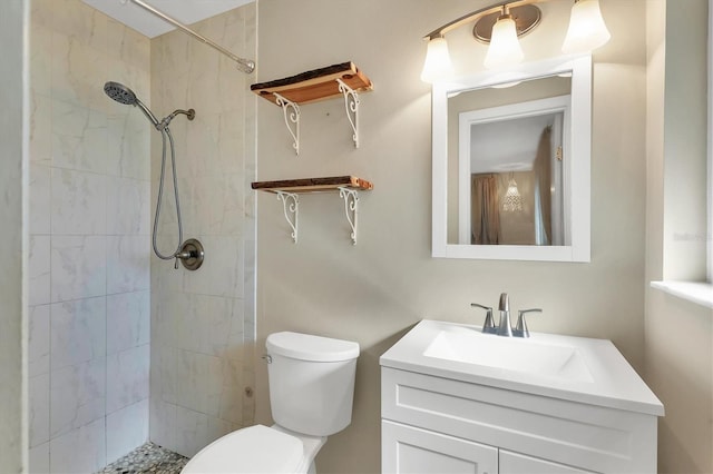 bathroom featuring tiled shower, vanity, and toilet