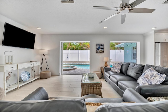 living room featuring a healthy amount of sunlight and ceiling fan