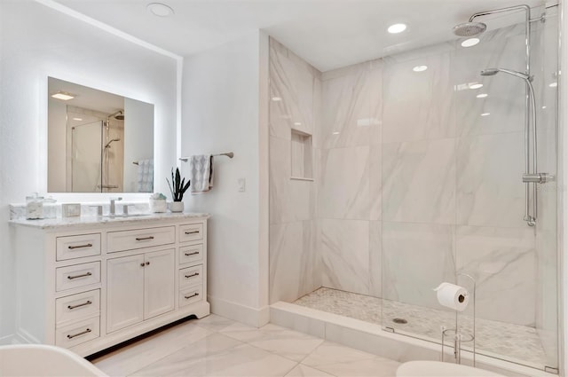 bathroom with tiled shower and vanity