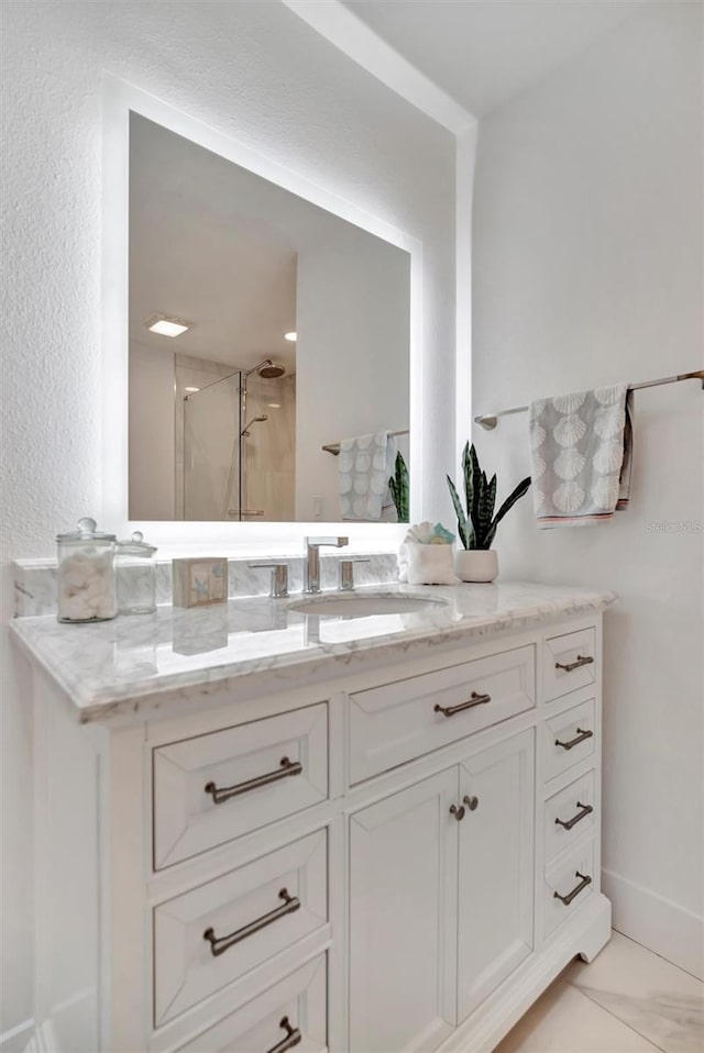 bathroom featuring vanity and a shower with door