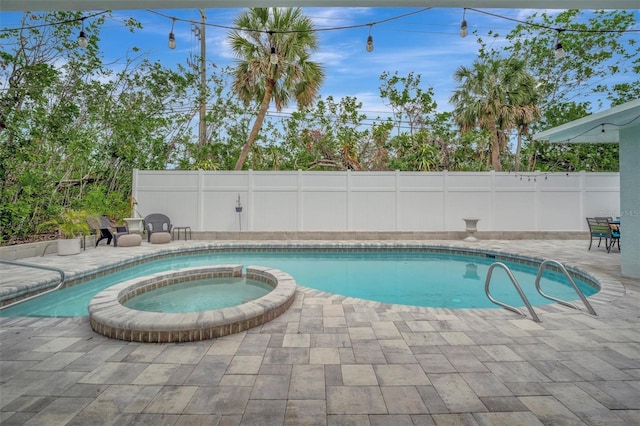 view of pool with a patio area and an in ground hot tub