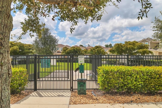 view of gate with a lawn