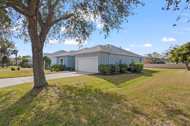 ranch-style home with a garage and a front lawn