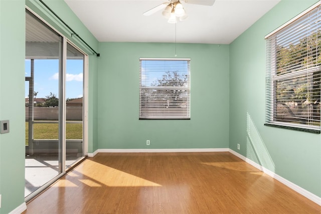 spare room with hardwood / wood-style flooring, a healthy amount of sunlight, and ceiling fan