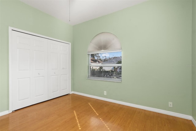 unfurnished bedroom featuring wood-type flooring and a closet