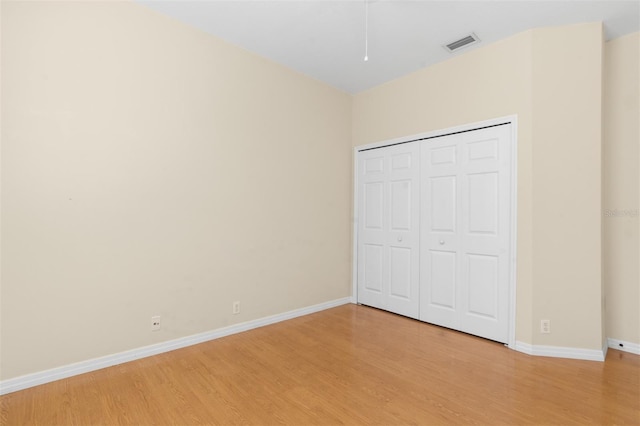 unfurnished bedroom featuring light hardwood / wood-style floors and a closet