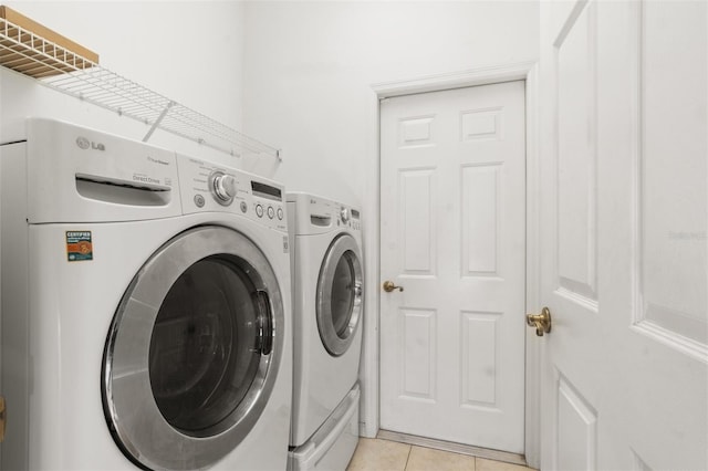 clothes washing area with light tile patterned floors and independent washer and dryer