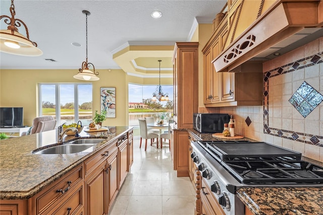 kitchen featuring premium range hood, a sink, range, stainless steel microwave, and an island with sink