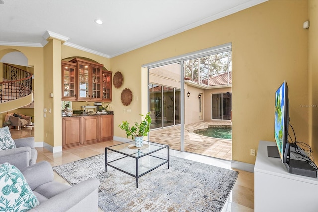 living room featuring ornamental molding, light tile patterned flooring, stairway, and baseboards