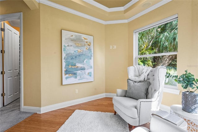 sitting room with baseboards, wood finished floors, and crown molding