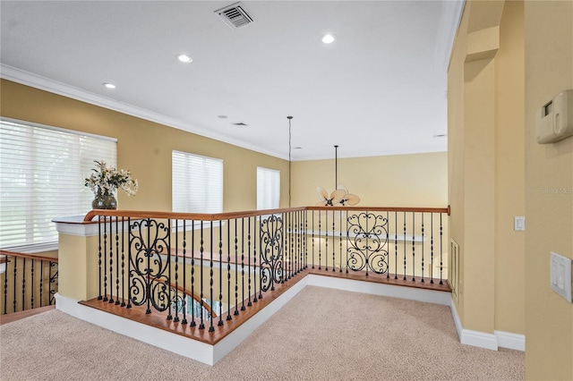 corridor with light carpet, a notable chandelier, visible vents, and crown molding