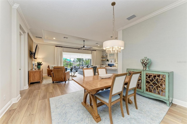 dining room with ornamental molding, a textured ceiling, and light wood-type flooring