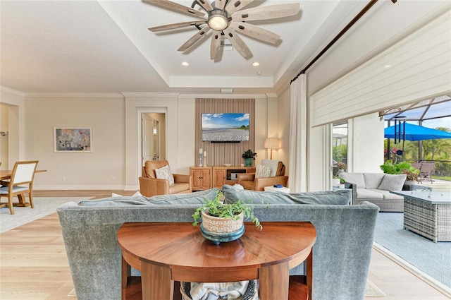 living room featuring crown molding, ceiling fan, and light hardwood / wood-style floors