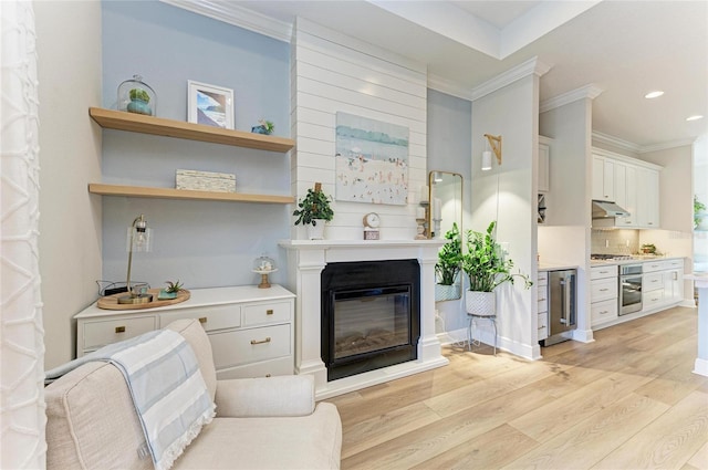 living room with ornamental molding, wine cooler, and light wood-type flooring