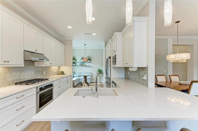 kitchen featuring pendant lighting, appliances with stainless steel finishes, a breakfast bar, and sink