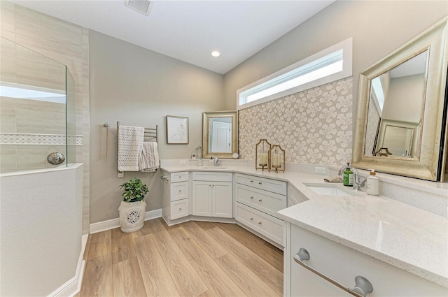 bathroom featuring wood-type flooring, vanity, and a shower