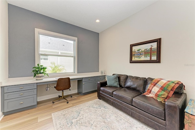 home office featuring light hardwood / wood-style flooring and built in desk