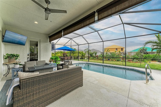 view of swimming pool with ceiling fan, an outdoor hangout area, glass enclosure, and a patio area