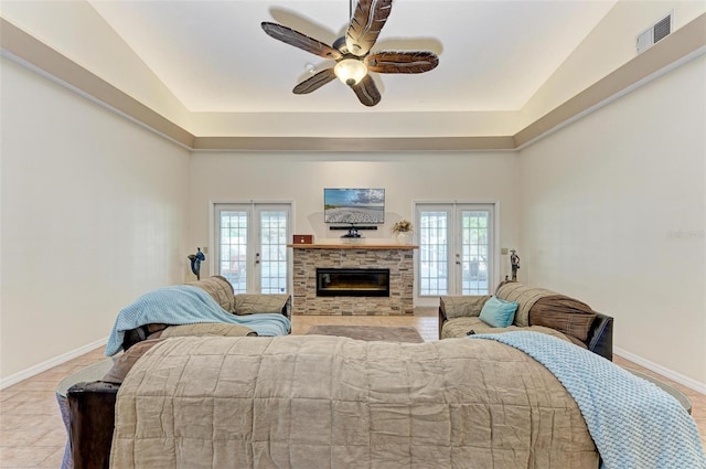 bedroom featuring multiple windows, access to outside, a fireplace, and french doors