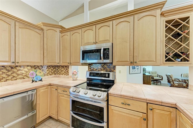 kitchen with light brown cabinetry, tile counters, and stainless steel appliances