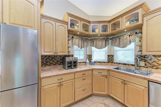 kitchen with appliances with stainless steel finishes, light brown cabinetry, and sink