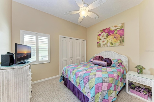 bedroom with ceiling fan, light colored carpet, and a closet