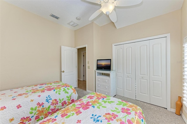 carpeted bedroom featuring ceiling fan and a closet