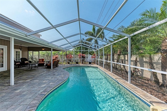 view of swimming pool featuring a lanai, a patio area, and ceiling fan