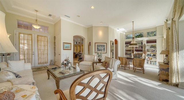 carpeted living room featuring french doors, crown molding, and a high ceiling