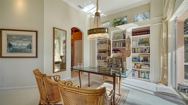 home office with carpet floors, ornamental molding, and a high ceiling