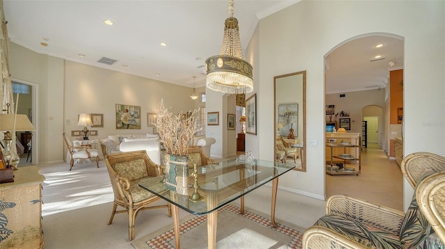 carpeted dining area featuring ornamental molding and a chandelier