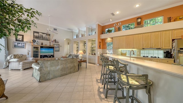 living room featuring light tile patterned flooring, plenty of natural light, and crown molding