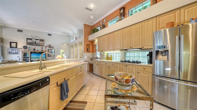 kitchen with decorative backsplash, light tile patterned floors, stainless steel appliances, crown molding, and light brown cabinets