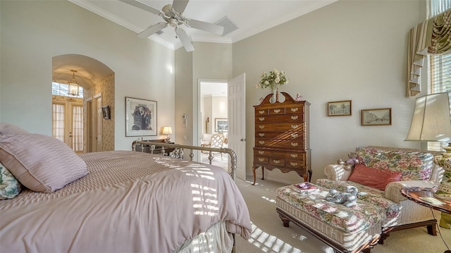 carpeted bedroom with ceiling fan, a towering ceiling, and ornamental molding