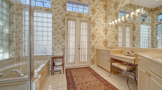 bathroom featuring tile patterned flooring, vanity, and a bath