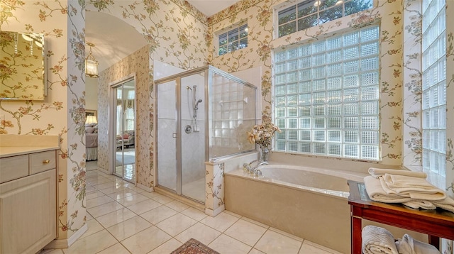 bathroom featuring plus walk in shower, vanity, and tile patterned floors