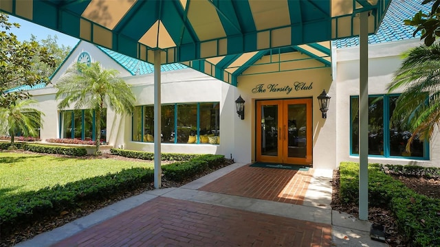 entrance to property with a lawn and french doors