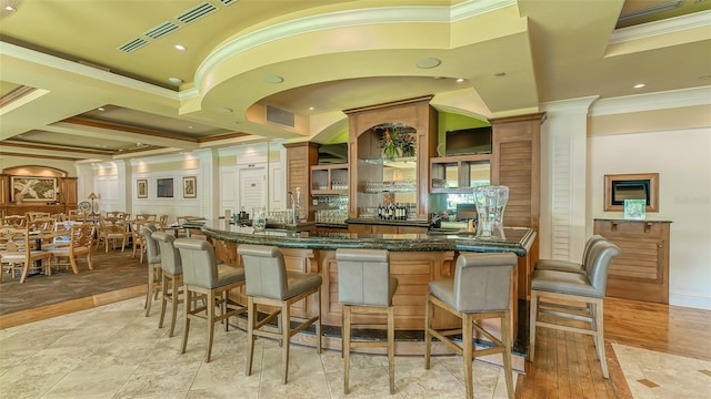 bar with crown molding and dark stone countertops