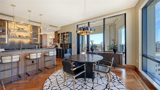 dining area featuring an inviting chandelier and dark parquet flooring