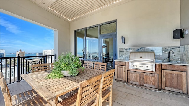 view of patio featuring an outdoor kitchen, grilling area, a pergola, and sink