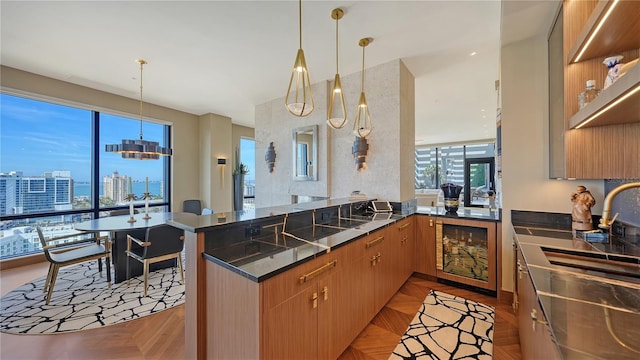 kitchen with decorative light fixtures, wine cooler, kitchen peninsula, light parquet flooring, and plenty of natural light